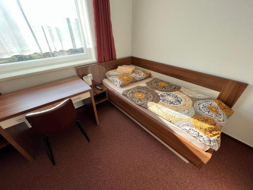 two beds in a room with a desk and a window at Ubytovanie pod Bielymi Karpatmi in Nové Mesto nad Váhom