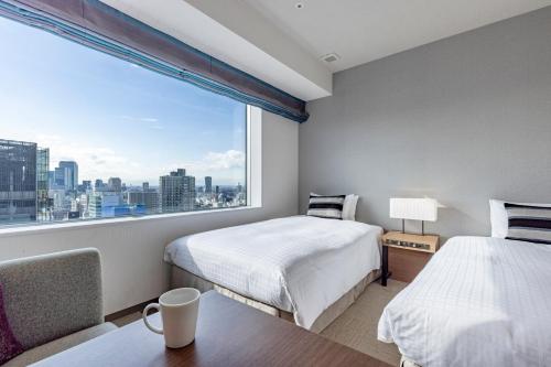 a bedroom with two beds and a large window at Tokyu Stay Aoyama Premier in Tokyo