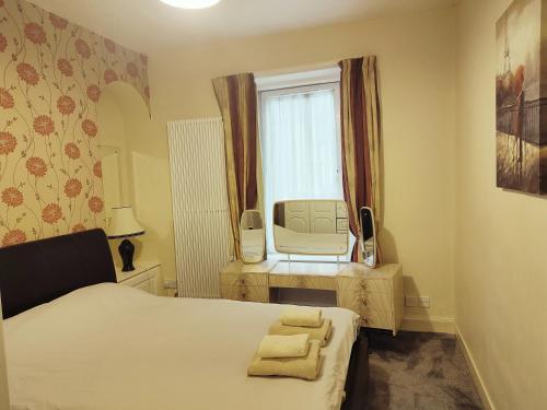 um quarto com uma cama e uma janela com uma cadeira em 2-level apartment em Aberdeen