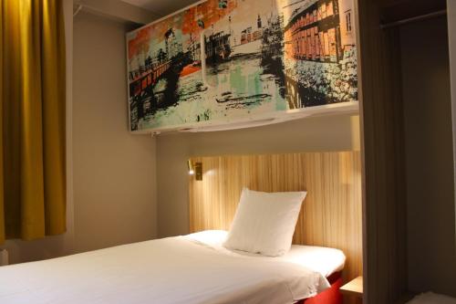 - une chambre avec un lit et une peinture murale dans l'établissement Good Morning Västerås, à Västerås