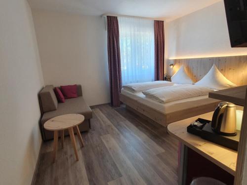 Habitación pequeña con cama y silla en Hotel Neuenburger Hof en Neuenburg am Rhein