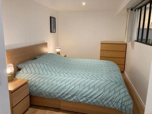 une chambre avec un lit avec une couette bleue dans l'établissement Le petit RepOzoir, une halte entre Paris et Disney, à Ozoir-la-Ferrière