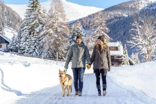 two people walking a dog in the snow at Apartment Elise in Patergassen