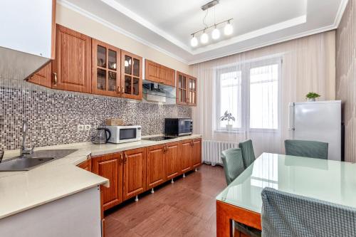a kitchen with wooden cabinets and a refrigerator at Апартаменты 2day apart у Байтерека in Astana