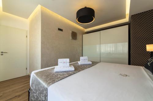 a bedroom with a white bed with two hats on it at The Queen Luxury Apartments - Villa Carlotta in Luxembourg