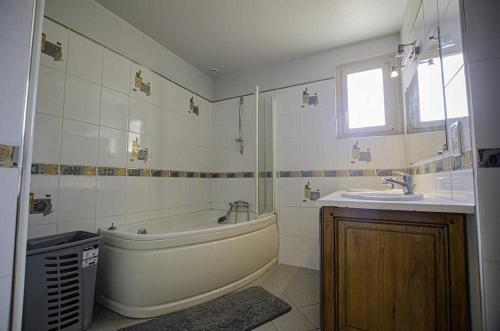 uma casa de banho com uma banheira e um lavatório em La claire vallee 