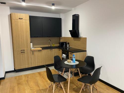 a kitchen with a table and chairs in a room at Slow River Apartment in Nowe Miasto Lubawskie