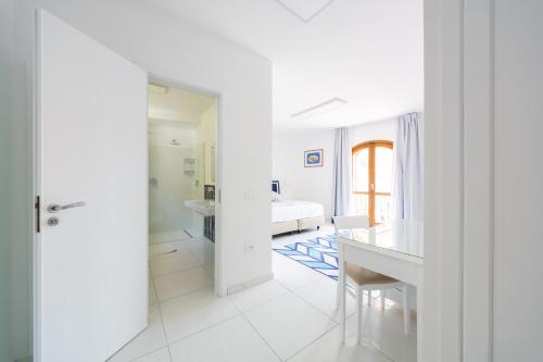 een witte kamer met een slaapkamer, een bureau en een bed bij Hotel San Francesco in Maiori