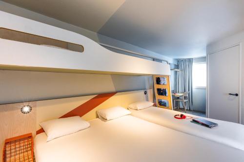a room with a bed with two pillows at ibis budget Angoulême Centre in Angoulême
