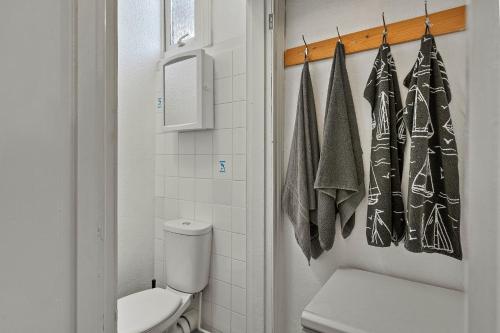 a bathroom with a toilet and towels on a rack at Finest Retreats - Atherfield Apartments No 7 - Sunny Side in Paignton
