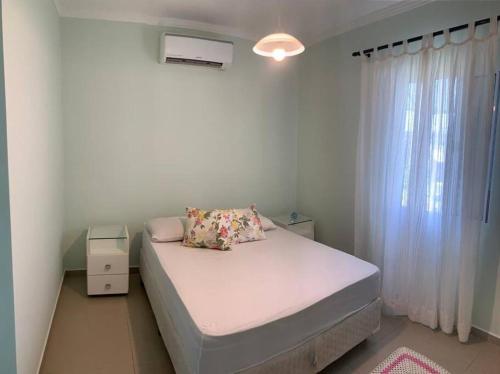 a small bedroom with a bed and a window at Descanso, pesca e praia in Iguape