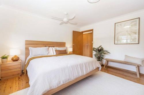 1 dormitorio blanco con 1 cama y ventilador de techo en Byron's Beach House Mylestom, en Mylestom