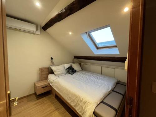 - une petite chambre avec un lit et une fenêtre dans l'établissement La casa del felicidad, à Bruyères-le-Châtel