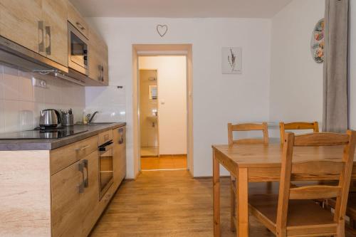 a kitchen with a wooden table and a dining room at Penzion Jizera Malá Skála in Malá Skála