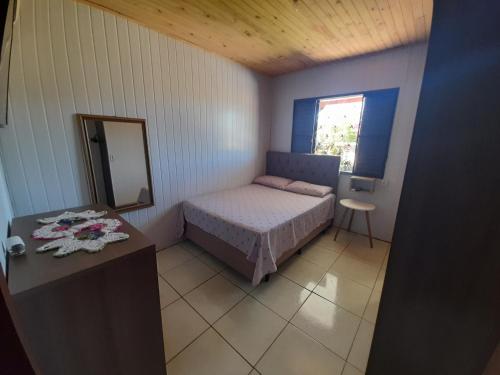 um pequeno quarto com uma cama e um espelho em Casa Encanto em São Miguel das Missões