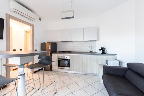 cocina y sala de estar con sofá y mesa en Malpensa Express en Vizzola Ticino