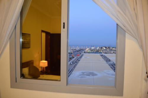 ventana en una habitación con vistas al aeropuerto en السعد للشقق المخدومة en Al Jubail