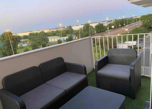 d'un balcon avec deux chaises et un canapé. dans l'établissement Redelpha, à Carrières-sous-Poissy