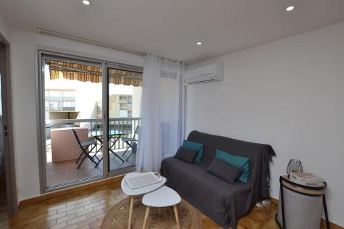 d'un salon avec un canapé et un balcon. dans l'établissement L'écrin au coeur de la citadelle, au Grau-du-Roi