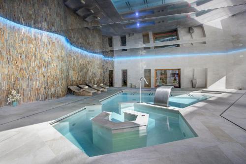 a room with a swimming pool in a building at MarSenses Rosa del Mar Hotel & Spa in Palmanova