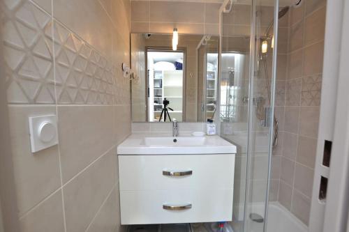 une salle de bain blanche avec un lavabo et une douche dans l'établissement L'écrin au coeur de la citadelle, au Grau-du-Roi