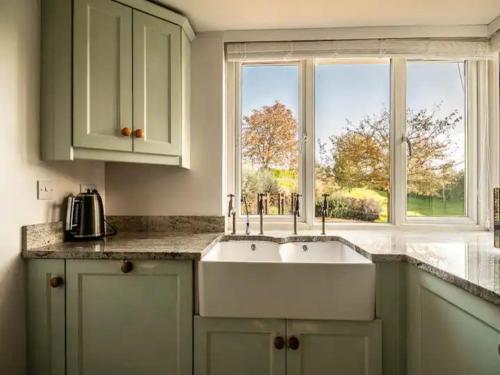 a kitchen with two sinks in front of a window at Pass the Keys Grand country home with space for all the family in Exeter