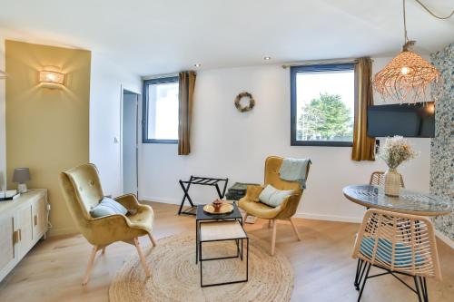 sala de estar con sillas y mesa en Les Voiles - Appart'hotel Le Groix, en Carnac