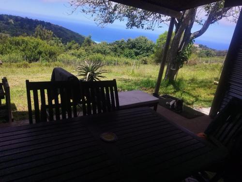 a porch with a bench and a view of the ocean at Map of Africa Luxury Caravan with private bathroom with sea view in Wilderness