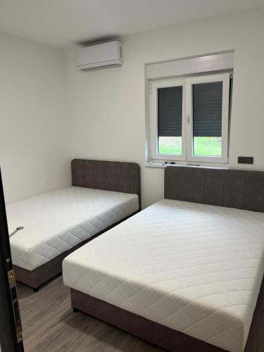 two beds in a room with two windows at LU DA kuca in Sveti Ivan Zelina