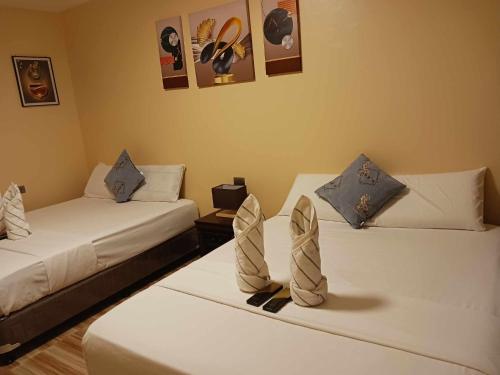 Una habitación con dos camas con zapatos. en INDINO GUEST HOUSE 2, en Moalboal