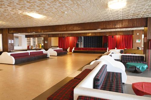 una sala de estar con sofás y cortinas rojas. en IL RIFUGIO DELLO SCIATORE/HOTEL PARADISO, en Roccaraso
