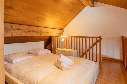 Schlafzimmer mit einem Bett mit weißer Bettwäsche und Kissen in der Unterkunft Apartment Genevrier in Chamonix-Mont-Blanc