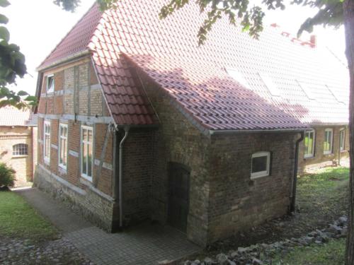 a brick house with a red roof at Ferienhaus an der Kirche in Groß Wokern