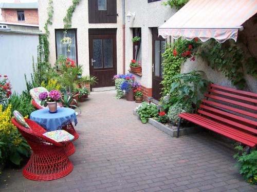 テーテローにあるFerienwohnung Altstadtblickの花の咲く建物の隣に座る赤いベンチ