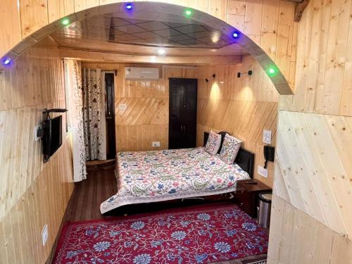a small room with a bed and a red rug at Gulmarg View Cottage in Gulmarg