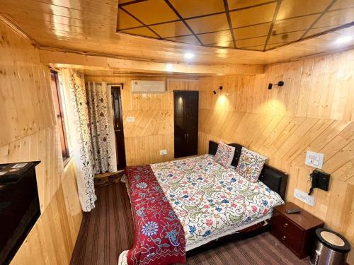 a bedroom with a bed in a wooden room at Gulmarg View Cottage in Gulmarg