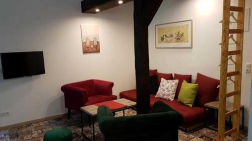 a living room with a red couch and a television at Ferien am Schloss Duckwitz in Duckwitz