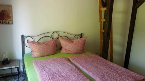 a bedroom with a bed with pink pillows at Ferien am Schloss Duckwitz in Duckwitz