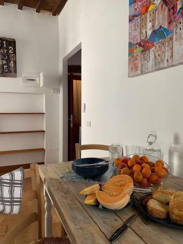 a wooden table with a bunch of fruit on it at The 4 Senses Experience in Suvereto