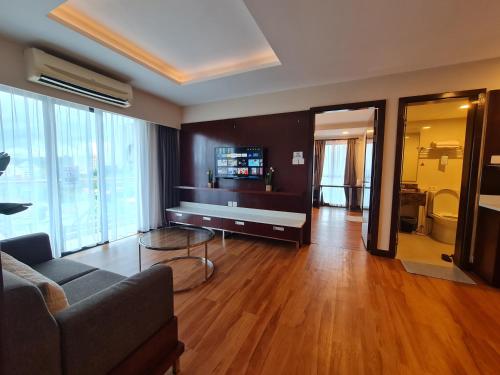 ein Wohnzimmer mit einem Sofa und einem TV in der Unterkunft BV2 HotelSuite homestay 2 bedrooms KK City Centre Near Imago in Kota Kinabalu