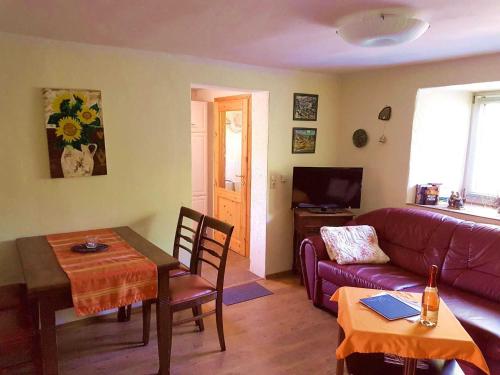 a living room with a purple couch and a table at Ferienhaus Grambzow in Hohen Demzin
