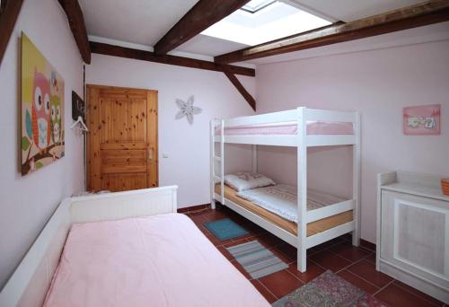 a bedroom with two bunk beds and a door at Ferien am Schloss Duckwitz in Duckwitz