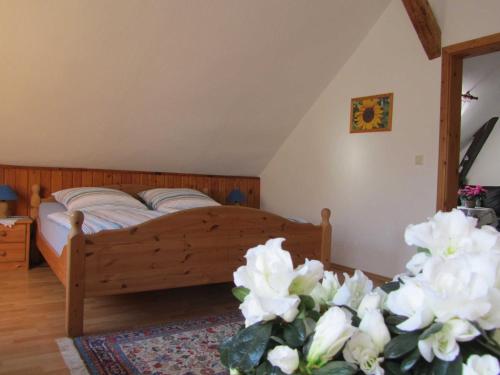 a bedroom with a bed with white flowers at Ferienwohnung Altstadtblick in Teterow