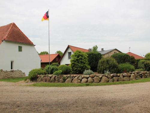 a flag flying over a house and a stone wall at Ferienhaus Grambzow in Hohen Demzin