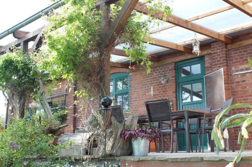 una casa de ladrillo con toldo, mesa y sillas en Ferienwohnung "Zum süßen Grund", en Groß Wokern