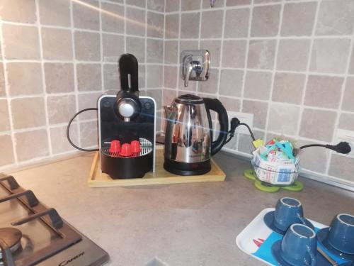 a kitchen counter with a coffee maker on a shelf at The 4 Senses Experience in Suvereto