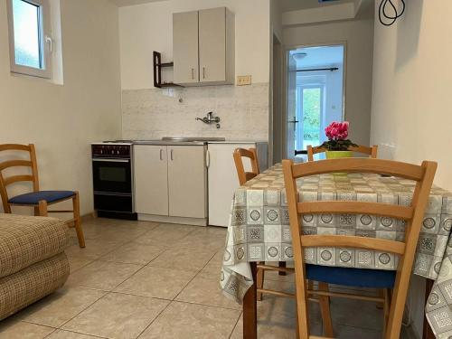 a kitchen with a table and chairs and a kitchen with a sink at Apartments and Room MV in Petrovac na Moru