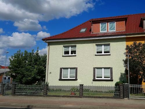 a white house with a red roof at Ferienwohnung Grapatin in Teterow