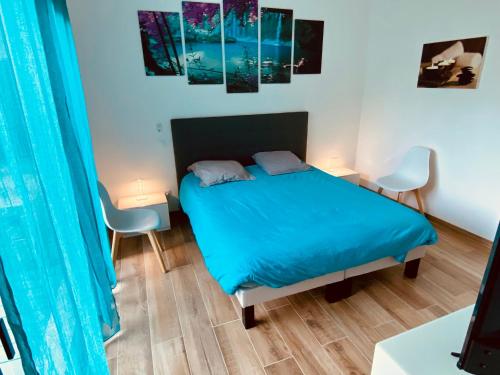 1 dormitorio con 1 cama azul y 2 sillas en Deux suites proche MEETT & aéroport, en Aussonne