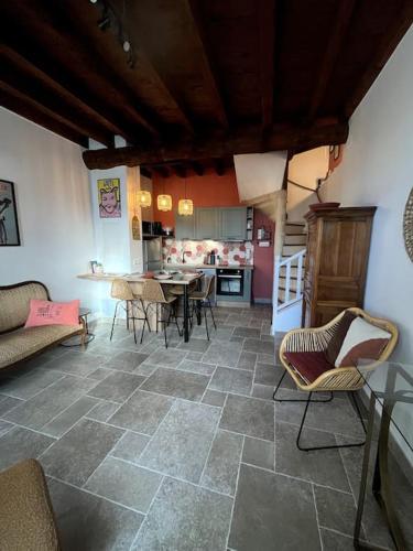 un salon avec une table et des chaises et une cuisine dans l'établissement La maison de Gaston*Arles*Arènes, à Arles